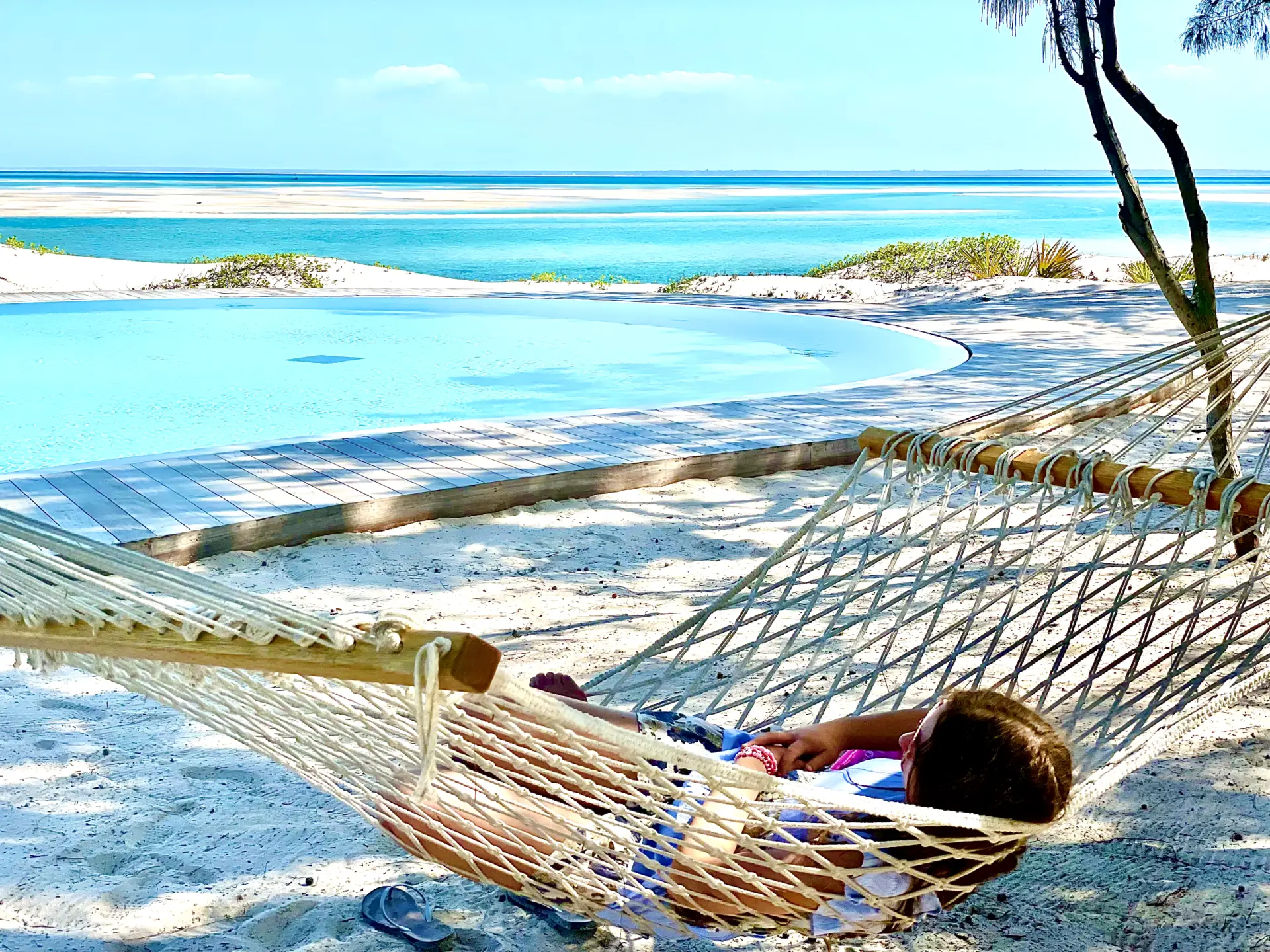 Someone relaxing on a sandy beach in Mozambique in a hammock